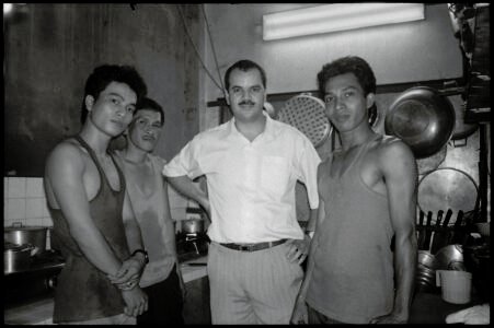 Photographic portrait of the Algerian owner of the restaurant Le Couscoussier and his staff, by Spiros Coutroubas, Ho Chi Minh City, Vietnam, 1996 Vietnam 1996: portrait of the Algerian owner of the restaurant Le Couscoussier and his staff, by Spiros Coutroubas - part of a series of documentary photographs of people and places in Vietnam in the 1990s